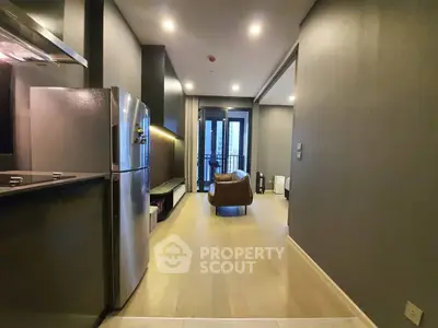 Modern apartment interior with sleek kitchen and cozy living area featuring stylish furniture.