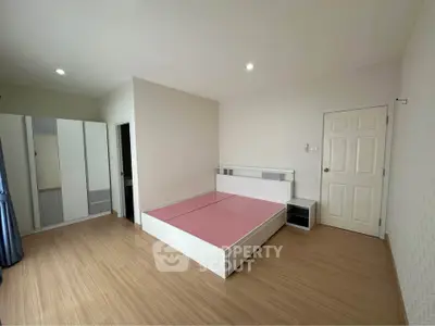 Spacious bedroom with modern furniture and wooden flooring