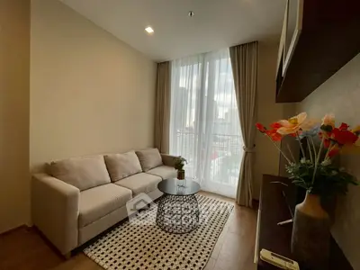 Cozy living room with modern decor and city view from large window.