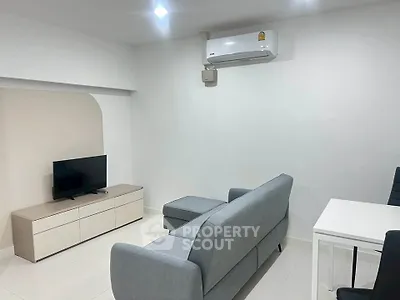 Modern living room with sleek furniture and wall-mounted air conditioner