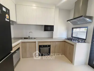Modern kitchen with sleek cabinetry, built-in oven, and gas stove in a contemporary home.