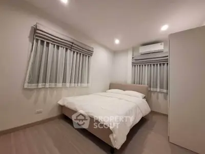 Cozy bedroom with modern design and soft lighting, featuring a comfortable bed and stylish window treatments.