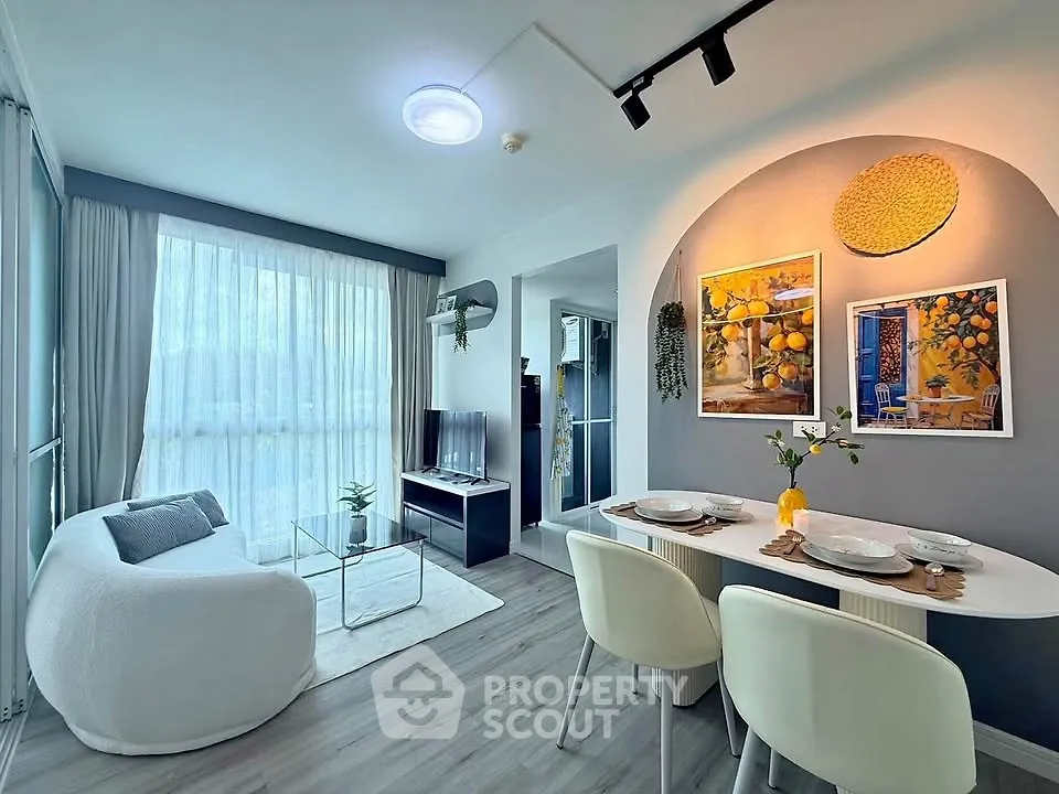 Modern living room with stylish decor and dining area, featuring large windows and cozy seating.