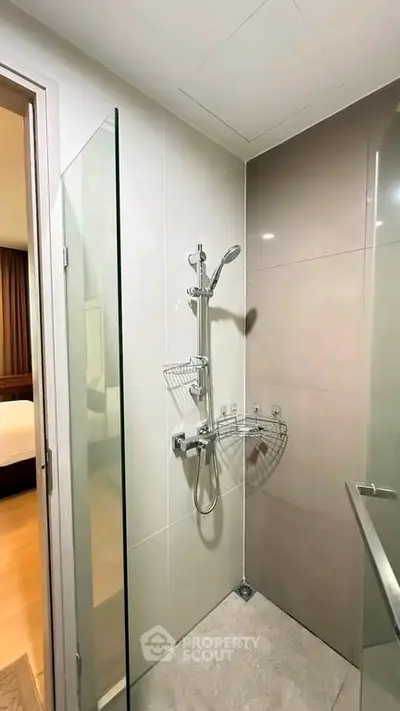Modern bathroom with sleek shower design and glass partition in a contemporary apartment.