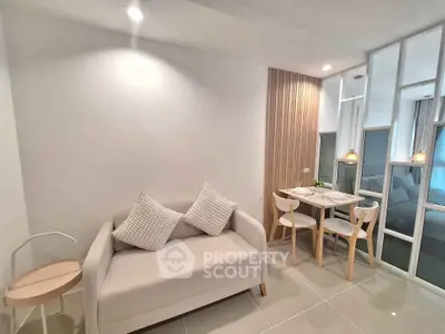 Modern living room with cozy seating and dining area, featuring stylish decor and bright lighting.