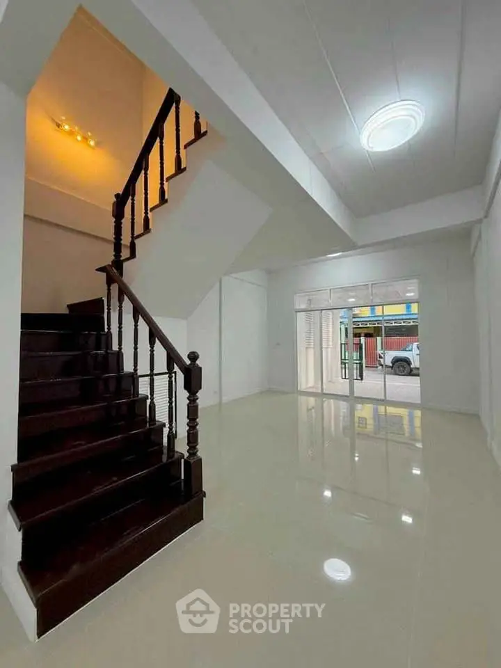 Spacious modern interior with elegant staircase and glossy tiled flooring, perfect for stylish living.