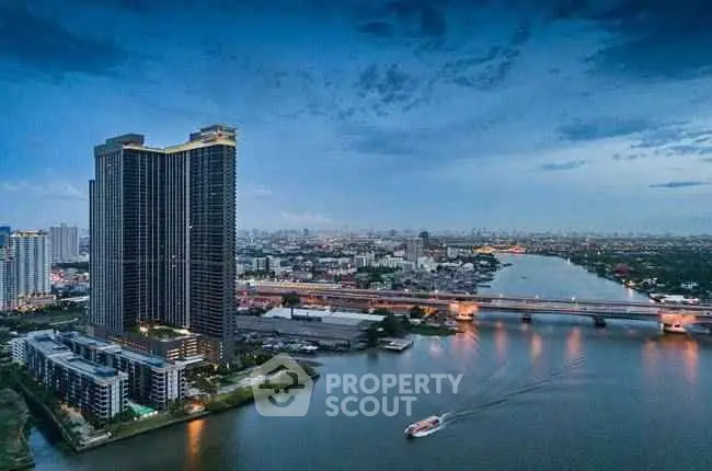 Stunning riverfront high-rise building with panoramic city views at dusk.