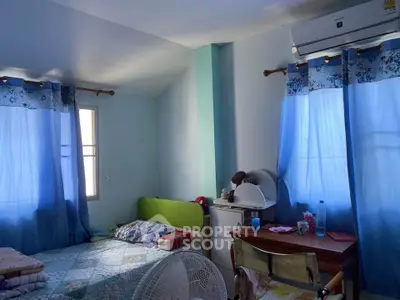 Cozy bedroom with blue curtains and air conditioning, perfect for a comfortable stay.