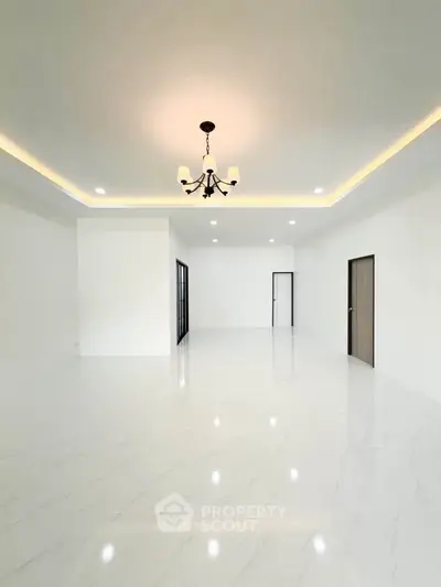 Spacious modern living room with elegant chandelier and marble flooring