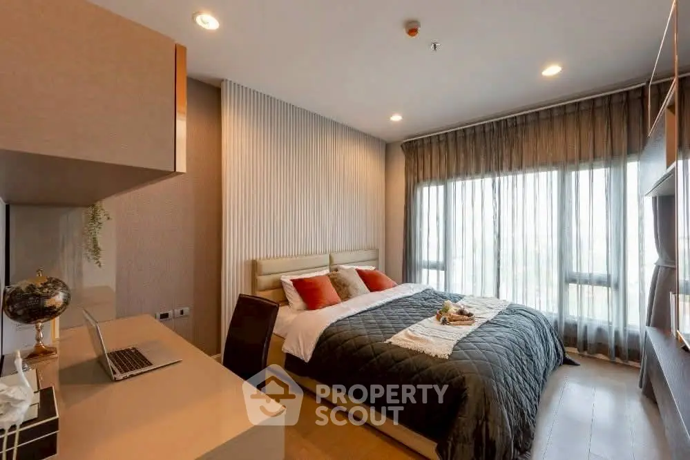 Luxurious bedroom with modern decor and large window offering natural light.
