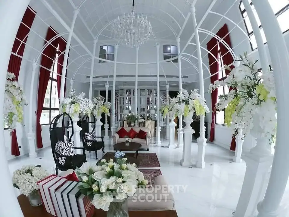 Luxurious living room with elegant decor and floral arrangements in a bright, airy space.