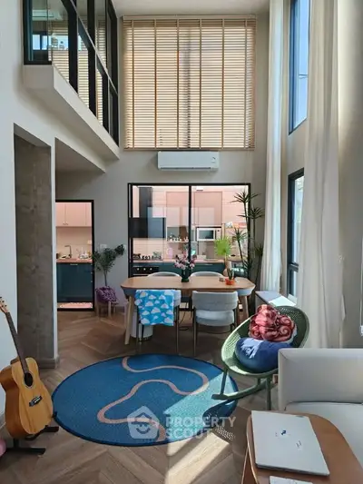 Modern living room with high ceilings, large windows, and stylish decor in a contemporary apartment.