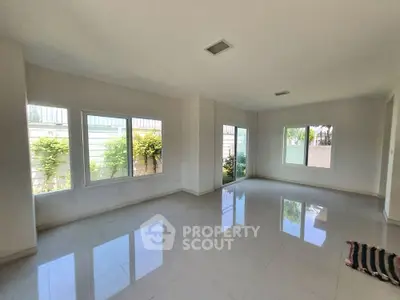Spacious empty living room with large windows and glossy tile flooring