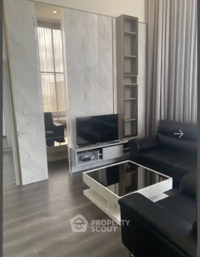 Modern living room with sleek black furniture and stylish marble accents