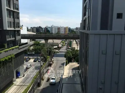 Urban cityscape view from a modern apartment building with street and greenery.