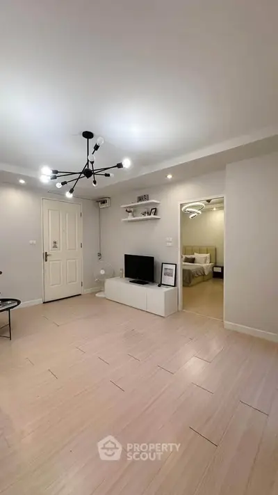 Spacious modern living room with stylish lighting and open access to bedroom
