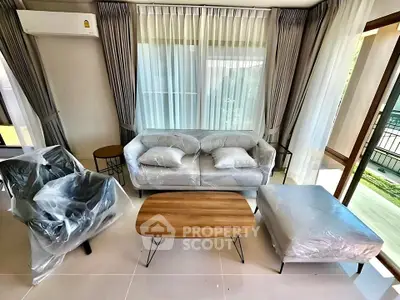 Modern living room with new furniture and large windows, offering a bright and inviting space.