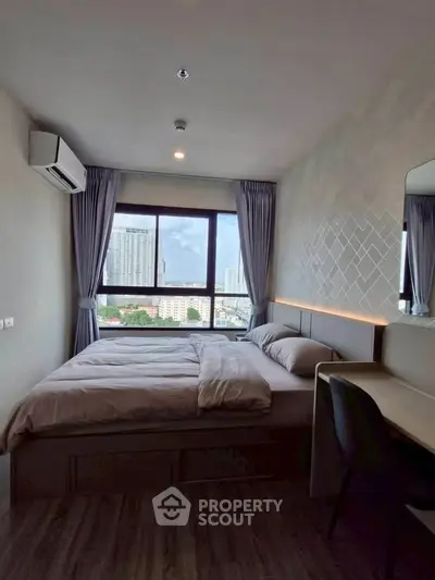 Modern bedroom with city view, featuring stylish decor and ample natural light.