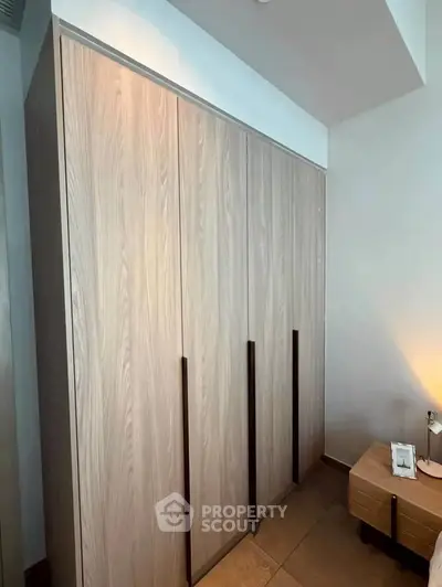 Modern bedroom with sleek wooden wardrobe and stylish nightstand