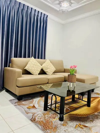 Elegant living room with beige sofa, glass coffee table, and stylish decor