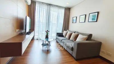 Modern living room with sleek furniture and large windows offering natural light.