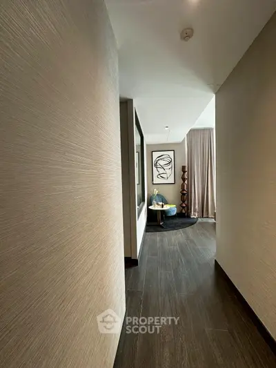Elegant hallway leading to a stylish living area with modern decor and artwork.