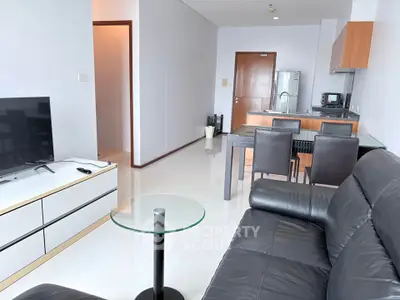 Modern living room with sleek furniture and open kitchen layout in a stylish apartment.