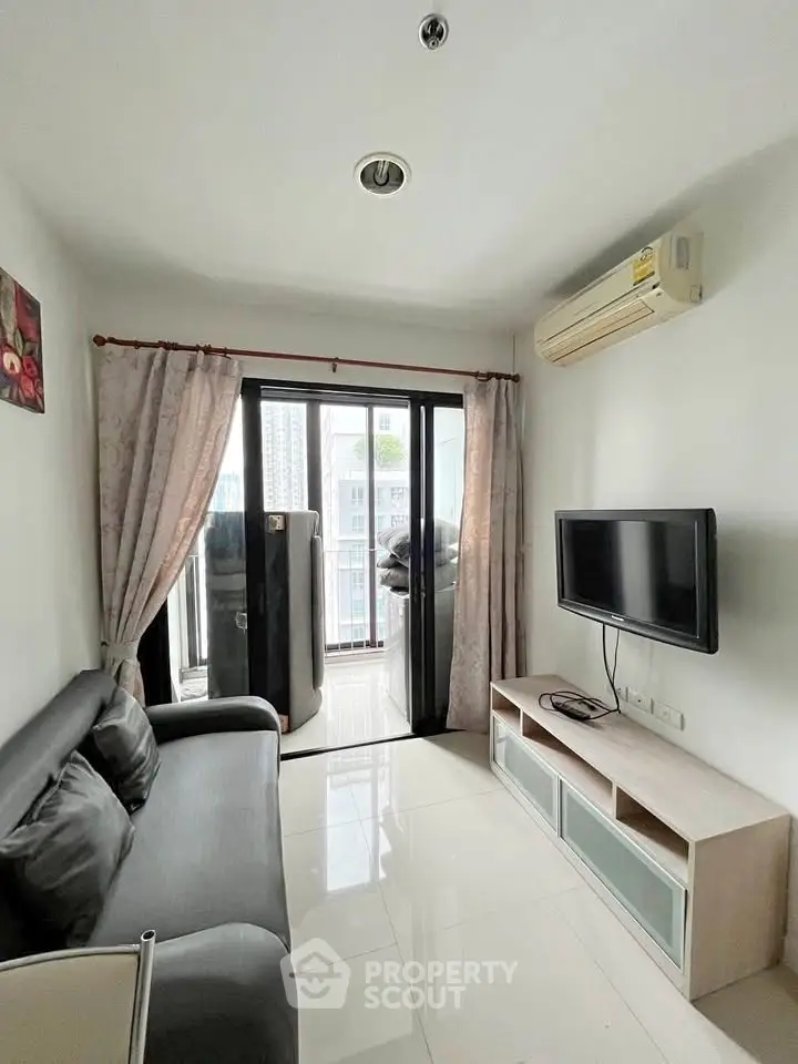 Modern living room with balcony view, sleek furniture, and air conditioning.
