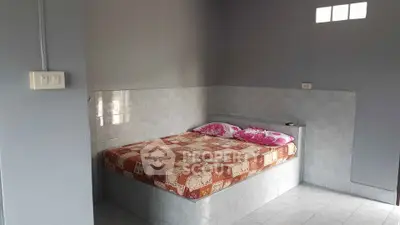 Cozy bedroom with tiled walls and a comfortable bed, perfect for a restful night's sleep.