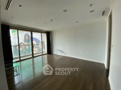 Spacious empty living room with large windows and wooden flooring