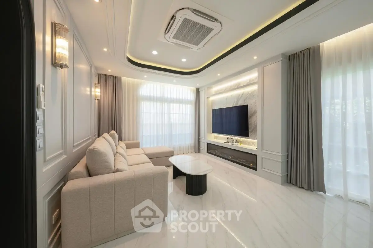 Luxurious modern living room with elegant sofa and large TV, featuring sleek design and ambient lighting.
