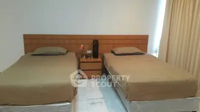 Spacious bedroom with twin beds and modern decor in a cozy apartment.