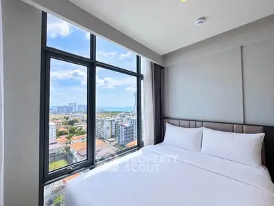 Bright bedroom with large windows offering stunning city views in modern apartment.