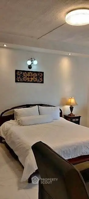 Cozy bedroom with elegant lighting and comfortable bedding in a stylish home.