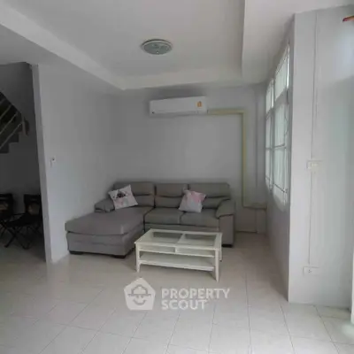 Spacious living room with modern sofa and air conditioning, perfect for relaxation and comfort.