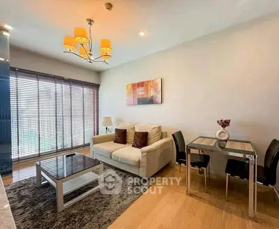 Modern living room with cozy sofa, stylish dining area, and elegant lighting in a bright apartment.