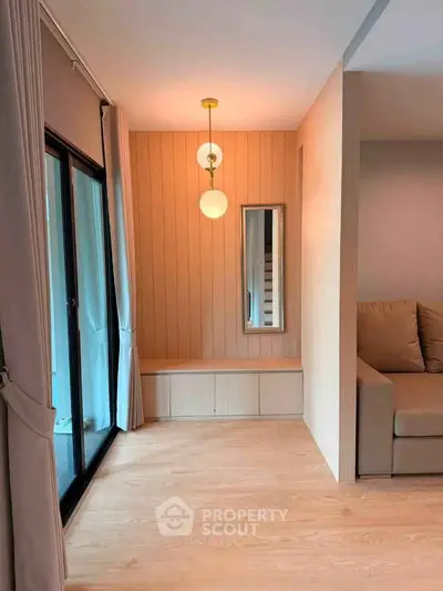 Modern living room with wooden flooring, stylish lighting, and cozy seating area.
