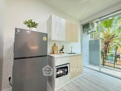 Modern kitchen with sleek appliances and balcony view, perfect for urban living.
