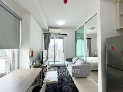 Modern apartment with open living room and bedroom, featuring city view and sleek furnishings.