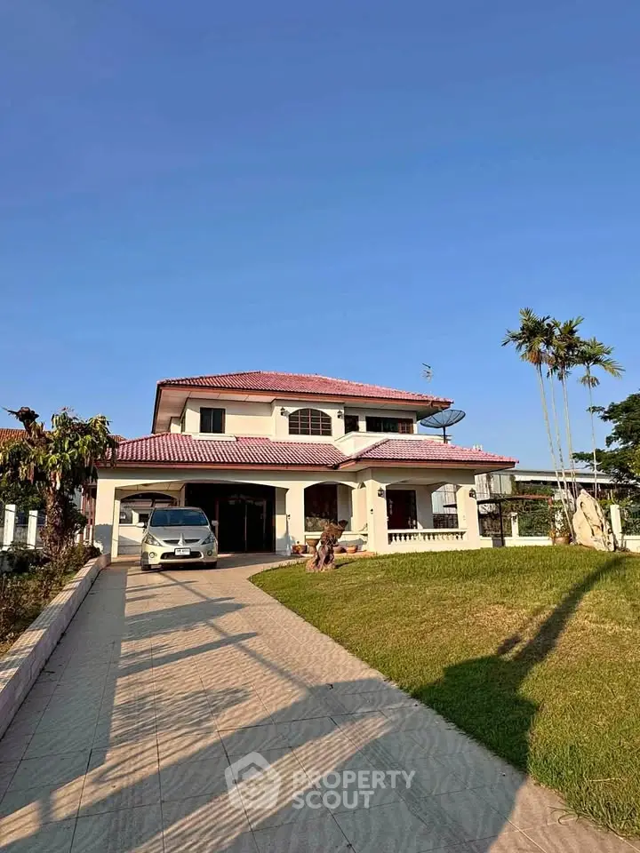 Stunning two-story house with red roof and spacious driveway in serene neighborhood.