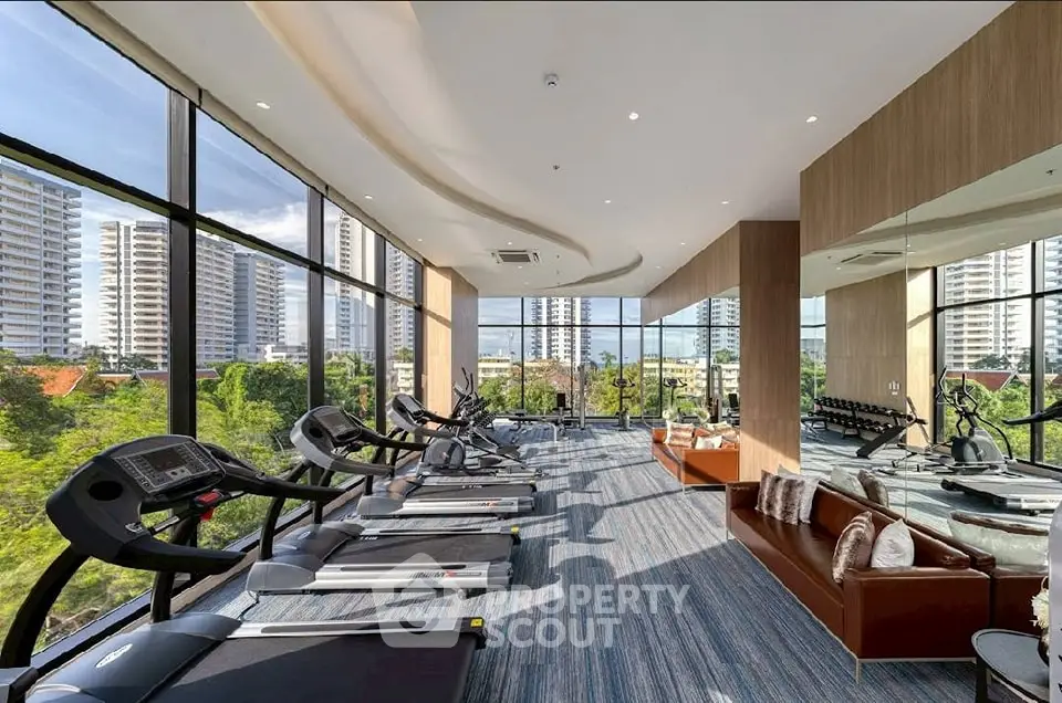 Luxurious gym with panoramic city views and modern fitness equipment.