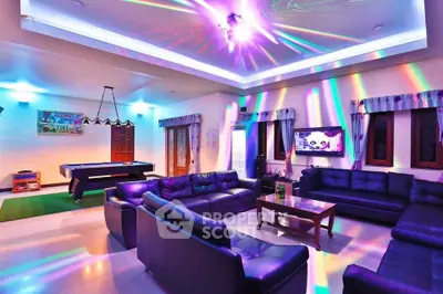 Luxurious living room with vibrant lighting and pool table, perfect for entertainment.