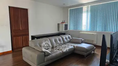 Modern living room with sleek gray sectional sofa and wooden accents