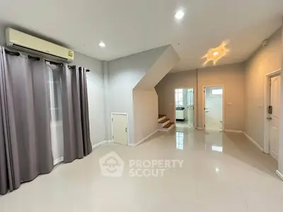 Spacious modern living room with staircase and sleek tile flooring