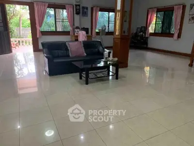 Spacious living room with sleek tile flooring and elegant decor, perfect for family gatherings.