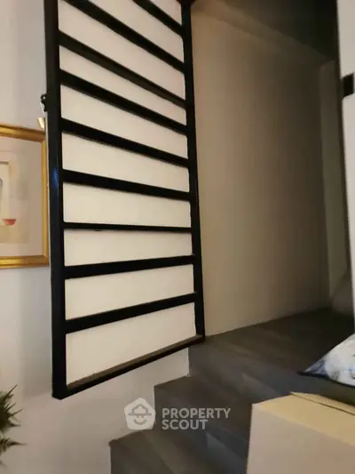 Modern staircase with sleek design and artistic wall decor in a stylish home interior.