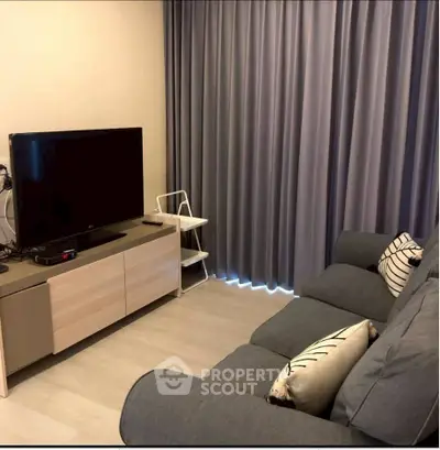 Cozy living room with modern sofa and entertainment center, perfect for relaxation.