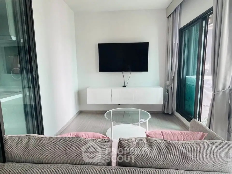 Modern living room with sleek TV setup and large windows