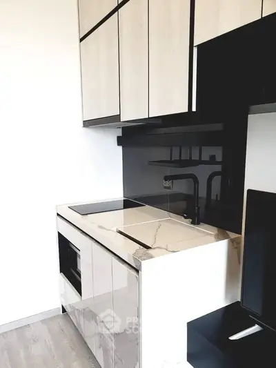 Modern kitchen with sleek cabinetry and marble countertop in a stylish apartment.