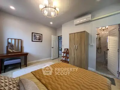 Spacious bedroom with ensuite bathroom, elegant lighting, and modern furnishings for a cozy living experience.